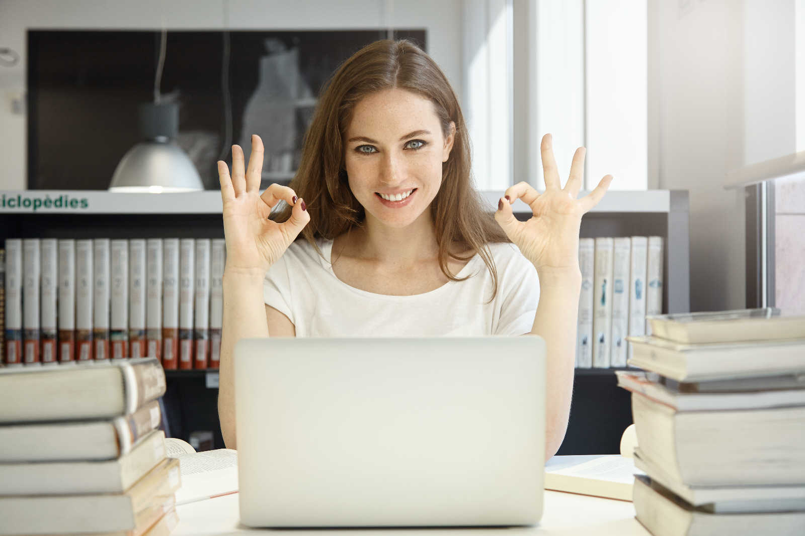 young woman sitting library with laptop kursy online